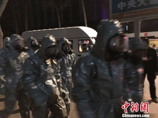 十几名身着防护服的人员头戴面具进入事发地。　胡健 摄